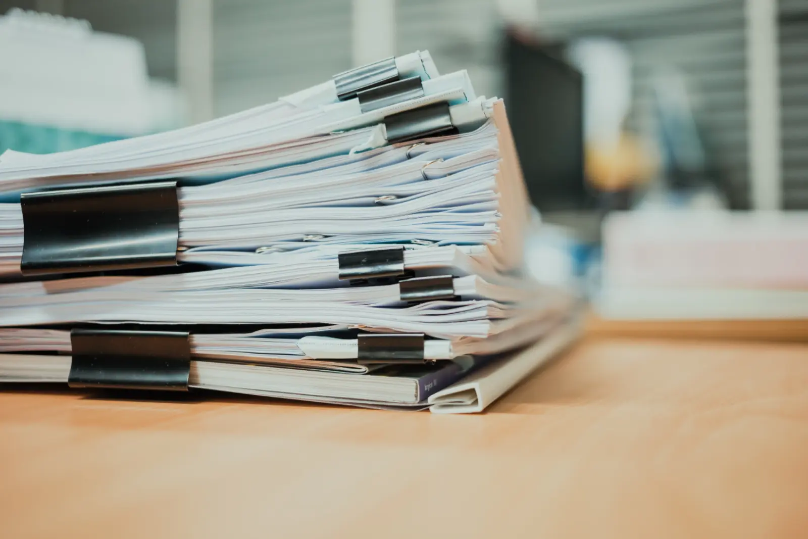 Stacked documents being reviewed in an institutional setting